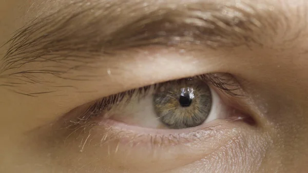 Close-up van het menselijk oog dat de concentratie op het object uitdrukt. Actie. man oog onder zonlicht kijken recht, staren. — Stockfoto