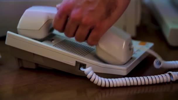 Close up of man hand picks up the white phone and pressing the button. Media. Using out of date white stationary phone. — Stock Video