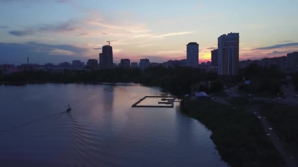 Vista aérea do rio e paisagem urbana no fundo do céu nublado do pôr do sol. Imagens de stock. Diferentes edifícios de uma cidade, conceito de natureza e urbanização. — Vídeo de Stock