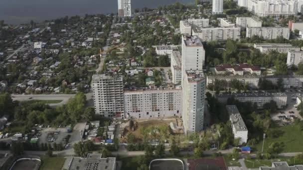 Aerial view of a cityscape and a river far in the distance. Action. Sleeping area, flying over the modern city district with streets and high rise buildings. — Stock Video