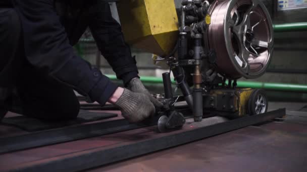 Beweging van apparatuur met wielen in de fabriek. Een knip. Ingenieur controleert de werking van machine-systeem met wielen. Werknemers rollen systeem met wielen langs lijnen om de mobiliteit te controleren — Stockvideo