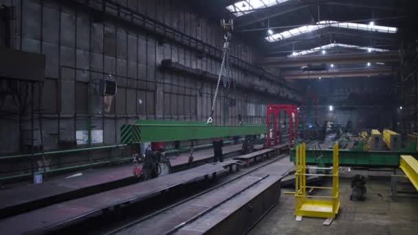 Metallträger werden in der Fabrik auf Ketten bewegt. Clip. An Ketten hängende Stahlträger werden in die Fabrik geschleppt. Schwebebalken an Ketten bewegt sich um Fabrik — Stockvideo