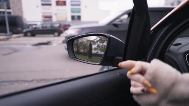 Blick aus dem Inneren eines Autos, Seitenspiegel und eine Frauenhand, die versucht, die Tür zu öffnen. Handeln. Details im Innenraum und ein Geländewagen, der hinter dem Fenster vorbeifährt. — Stockvideo