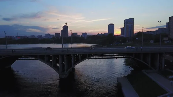 Aerial view of the river and cityscape on the background of cloudy sunset sky. Stock footage. Different buildings of a town, concept of nature and urbanization. — Stock Photo, Image