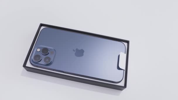 MOSKAU, RUSSLAND-NOVEMBER, 2020: Neues iPhone-Modell im Karton. Handeln. Neuestes iPhone-Modell mit stylischem Gehäuse und drei Kameras im Paket. Neues iPhone von Apple im Paket auf weißem isolierten Hintergrund — Stockvideo