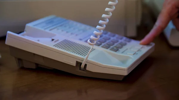 El primer plano de la mano del hombre recoge el teléfono blanco y presiona el botón. Medios. Usando teléfono fijo blanco desactualizado. — Foto de Stock