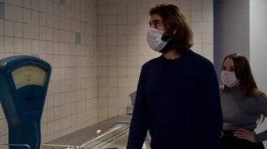 Maskeli adam ve kadın, eski moda Sovyet pullarının yakınında bir kasiyer için sırada bekliyor. Medya. 80 'lerin sonunda malların ve boş tezgahların olmadığı SSCB dönemi kavramı.