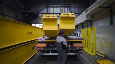 Köprü vinci. Şarjör. Büyük sarı metal kirişli bir depo. Ana kirişleri ve kamyonu olan sanayi deposu.