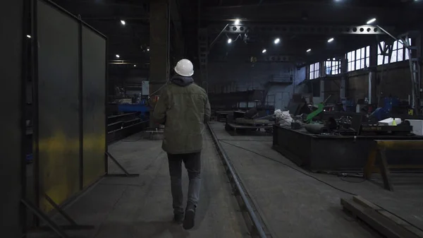 Mannen går runt fabriken och ser sig omkring. Klipp. Foreman övervakar arbete och produktion av alla delar av anläggningen. Ingenjör eller förman övervakar produktionen på fabriken — Stockfoto