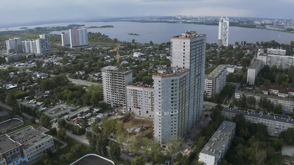 Vista aérea de un paisaje urbano y un río a lo lejos. Imágenes de archivo. Zona de dormir, volando sobre el moderno barrio de la ciudad con calles y edificios de gran altura. —  Fotos de Stock