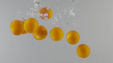 Çilekler izole arka planda suya düşer. Başla. Meyveler kabarcıklarla suya düşer. Hafif arkaplandaki dutların ferahlatıcı düşüşü