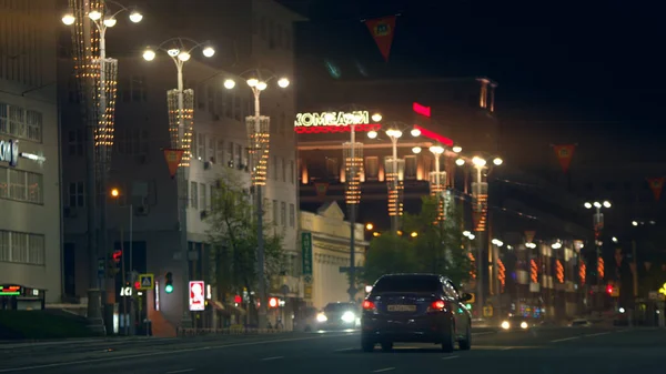 Vista sulla strada la sera con veicoli in movimento. Filmati delle scorte. Vista notturna di lanterne e edifici decorativi su sfondo cielo nero. — Foto Stock