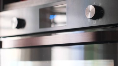 Lezzetli yemekler pişirmek için elektrikli fırın kullanmak. Kavram. Kadın ellerinin fırını açtığı yeri kapat ve fırından fırın örtüsü al..