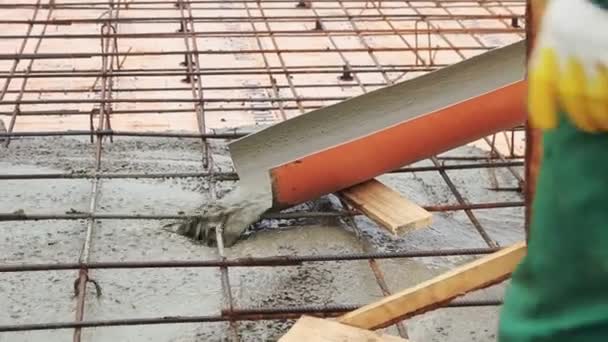 Betonmischung auf das Bewehrungsnetz und ein Hausfundament gießen. Clip. Flüssiger Zement auf einer Baustelle. — Stockvideo