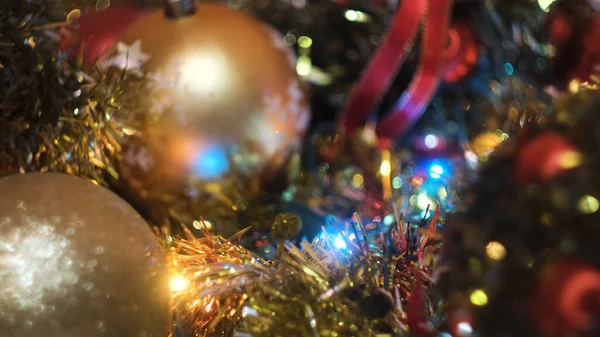 赤いプラスチック輝くクリスマスボールを取って女の子の手を閉じる。コンセプト。お正月、おもちゃやトウヒの装飾のためのガーランド. — ストック写真