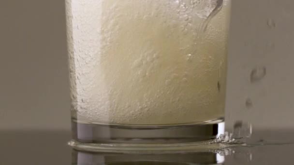 スローモーションでソーダ水でガラスを充填.ストック映像だ。透明なガラスの中に多くの泡でソフトドリンクを注ぐのを閉じる. — ストック動画