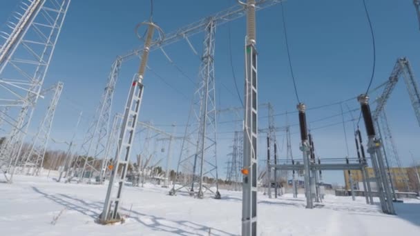 Postes y cables de la central eléctrica en invierno. Acción. Central eléctrica en el campo en el soleado día de invierno. Hermosa planta de energía con muchos postes y conductores de cable — Vídeos de Stock