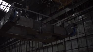 Ağır endüstri konsepti, fabrika atölyesinin içinde. Şarjör. Büyük bir metal yapısının taşınma sürecinin alt görüntüsü.