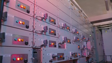 Elektrik kontrol istasyonu kalkanı. Başla. Çoklu kontrol hücreleri olan endüstriyel elektrik ekipmanları. Elektrik endüstrisindeki kontrol panellerinde birçok düğme yanıyor