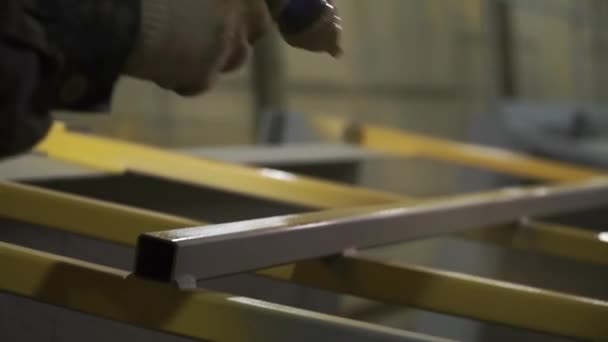 Processus de peinture d'une construction métallique à l'usine industrielle moderne. Clip. Gros plan sur la coloration d'un détail gris en jaune. — Video