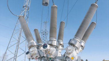 Elektrik trafosu alt istasyonda. Başla. Elektrik trafosundaki benzin deposu anahtarı. Mavi gökyüzünün arka planında yüksek iletken ekipmanlar