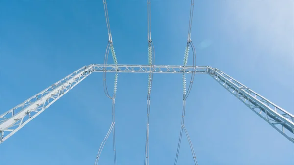 Postes de energía en el fondo del cielo azul. Acción. Hermosos postes eléctricos sobre fondo azul del cielo. Subestación eléctrica con postes y cables. Industria de generación y transmisión de energía —  Fotos de Stock