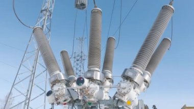 Elektrik trafosu alt istasyonda. Başla. Elektrik trafosundaki benzin deposu anahtarı. Mavi gökyüzünün arka planında yüksek iletken ekipmanlar