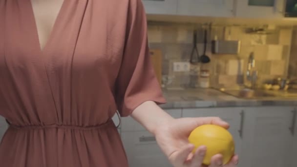 Mulher a atirar limão nas mãos. Acção. Close-up de mulher magistralmente joga limão de mão em mão. Mulher brinca com limão antes de cozinhar. Cozinha caseira profissional — Vídeo de Stock