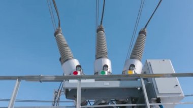 Elektrik trafosu alt istasyonda. Başla. Elektrik trafosundaki benzin deposu anahtarı. Mavi gökyüzünün arka planında yüksek iletken ekipmanlar