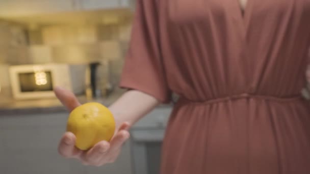 Femme jetant du citron dans les mains. L'action. Gros plan de la femme jette magistralement le citron de main en main. Femme joue avec le citron avant la cuisson. Cuisine professionnelle à domicile — Video