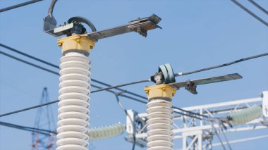 Mavi gökyüzünün arka planında elektrik direkleri var. Başla. Mavi gökyüzü arka planında güzel elektrik direkleri. Direkleri ve kabloları olan elektrik santrali. Güç üretimi ve iletim endüstrisi