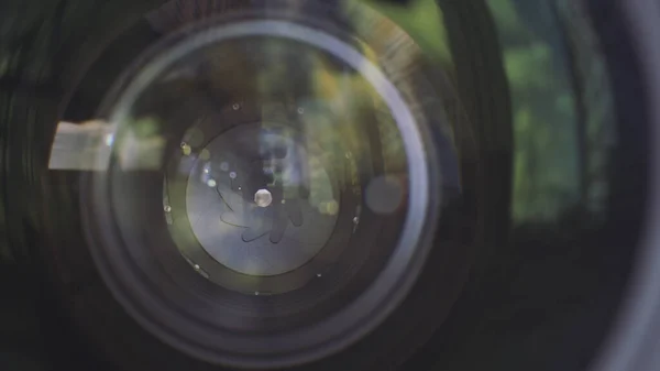 Abertura da lente da câmera de perto. Acção. Vista ao ar livre de uma câmera profissional lense com abertura de lâminas fechadas. — Fotografia de Stock