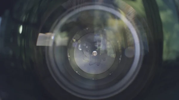 Abertura da lente da câmera de perto. Acção. Vista ao ar livre de uma câmera profissional lense com abertura de lâminas fechadas. — Fotografia de Stock
