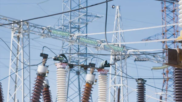 Poteaux électriques sur fond de ciel bleu. L'action. Beaux poteaux électriques sur fond bleu ciel. Sous-station électrique avec poteaux et câbles. Production et transport d'électricité — Photo