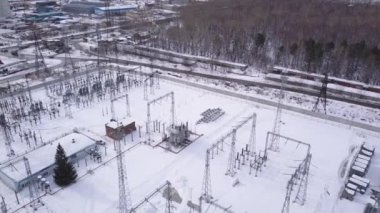 Yüksek voltajlı elektrik hattının hava görüntüsü. Başla. Orman yakınlarındaki sanayi bölgesi ve elektrik nakil hatlarıyla kış manzarası.