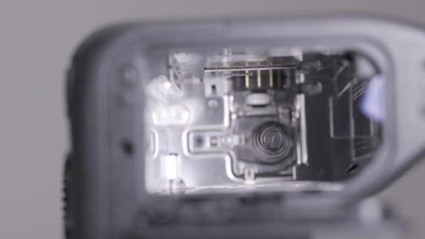 Extreme close-up van een lege sleuf voor de batterij van een foto- en videocamera. Actie. Oplaadelementen van een wisselbare batterij. — Stockvideo
