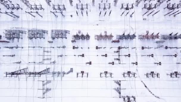 Elektromos rudak sorai. Felvétel. A villamos alállomás csúcsnézete transzformátorsorokkal télen. Erős elektromos alállomás új felszereléssel télen. Villamosenergia-ipar — Stock videók
