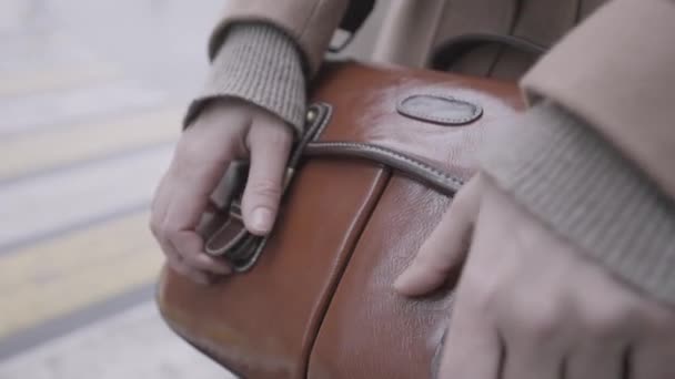 Woman leather sack with two golden metal rivets. Action. Close up of female hand opening a beautiful brown genuine leather bag and looking for something inside. — Stock Video