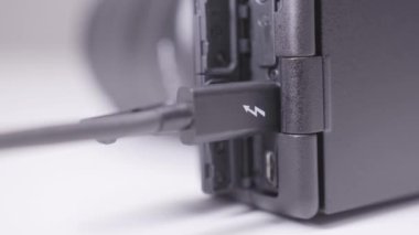 Siyah elektronik cihazın kablolu görüntüsü. Başla. Şarj kablosu boşaltılmış kameraya bağlı. Kablo kullanarak fotoğraf makinesinden yükleme ve içeriye aktarma