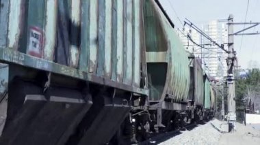 Yük treninin yanından geçerken yaklaş. Şarjör. Taşımacılık ve lojistiğin güvenilirliği, teslimat ve ulaşım konsepti, yük vagonlarının taşınması.