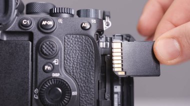 Rusya, MOSCOW-ARALIK, 2020: kameradaki hafıza kartı. Başla. Yakın plan fotoğrafçı kameraya yeni hafıza kartı takıyor. Hafıza kartı kameraya yerleştiriliyor