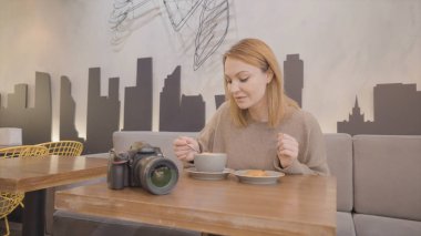 Kafede tek başına yemek yiyen güzel bir kadın. Başla. Kadın kafede tek başına yemek yiyor. Kadın fotoğrafçı kafede öğle yemeği molası verdi.