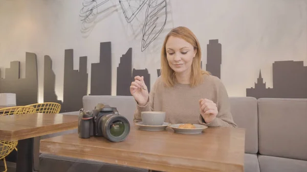 Schöne Frau, die allein im Café isst. Handeln. Frau isst allein im Café zu Mittag. Fotografin machte Mittagspause im Café — Stockfoto