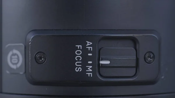 Extreme close-up van cameralens details. Actie. Handmatige MF en automatische AF scherpstelknop aan en uit aan de zijkant van professionele camera. — Stockfoto