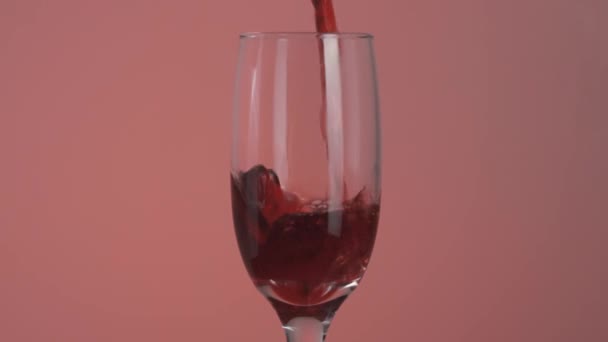 El primer plano del jugo de cereza o granada se vierte en un vaso. Acción. Llenar un vaso transparente con un delicioso jugo, concepto de dieta de vitaminas. — Vídeos de Stock