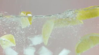 Limon dilimlerinin berrak sudaki tazeliği, yakın çekim. Başla. Citrus doğal içeceği, bol miktarda C vitamini, sağlıklı ve taze içecek kavramı..