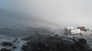 Karavan ve makinelerle dolu bir jeolojik üssün tepesinden görüntü. Şarjör. Dağlardaki sisli hava karla kaplı, bilim konsepti.