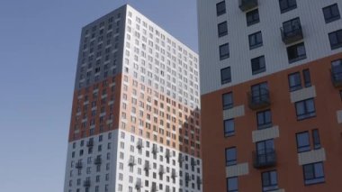 Camdan pencereleri ve küçük balkonları olan yüksek katlı yeni apartman binalarının ön cephesi. Başla. Uygun fiyatlı konut kavramı.