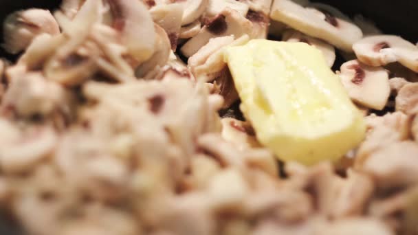 Τηγανητό κρέας κοτόπουλου, μανιτάρια και βούτυρο σε τηγάνι. Έννοια. Κοντινό πλάνο της προετοιμασίας φιλέτου κοτόπουλου με champignons και το βούτυρο λιώνει σε ένα τηγάνι. — Αρχείο Βίντεο