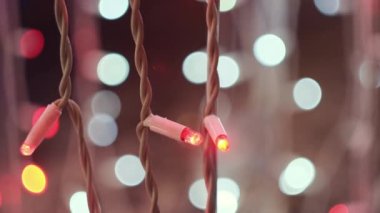 Bokeh 'in arka planında yanıp sönen LED Noel çelenkleri bulanık ışıklar. Kavram. Açık pembe renkli yanıp sönen ışıkları kapatın, Yeni yıl ve Noel zamanı.